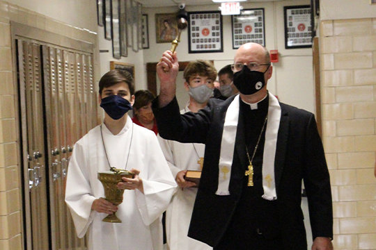 Bishop McKnight blesses Sacred Heart School with holy water during his Sept. 4 visit.
